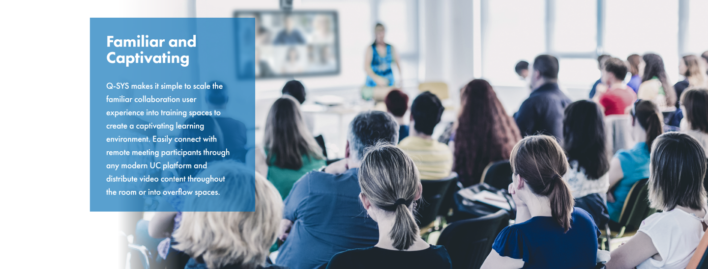 Q-SYS周辺機器を備えたトレーニングルームで、誰かがトレーニングするのを見ている従業員の後ろ姿